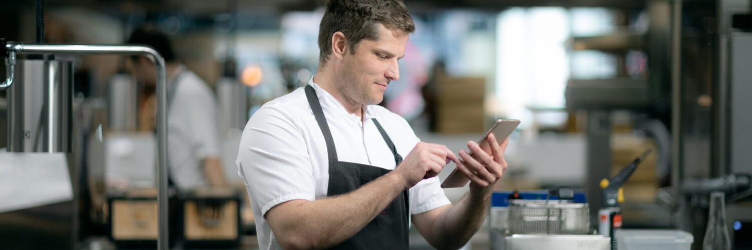 Kökschef loggar egenkontroll på ipad i ett professionellt storkök